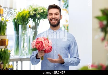 Glücklicher lächelnder Mann mit Blumenstrauß Stockfoto