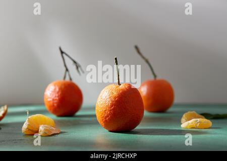 Stillleben mit Mandarinen auf grünem Hintergrund Stockfoto