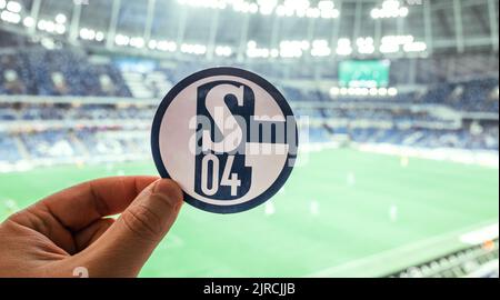 12. September 2021, Gelsenkirchen, Deutschland. Das Emblem des Fußballvereins FC Schalke 04 vor dem Hintergrund des modernen Stadions. Stockfoto