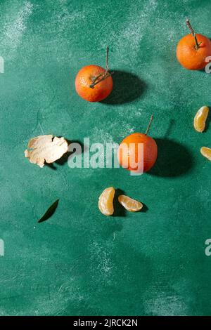 Stillleben mit Mandarinen auf grünem Hintergrund Stockfoto