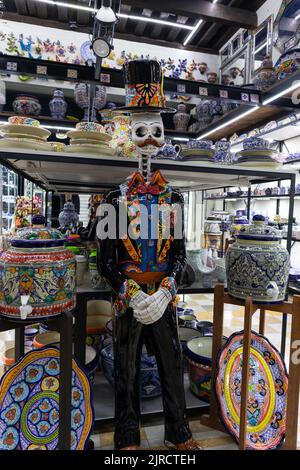 Puebla Stadt, Puebla, Mexiko - 08 2022. August: Töpferskulptur Statue eines traditionellen catrin Tag des toten mexikanischen Skelett Schädels mit einem Hut in einem Stockfoto