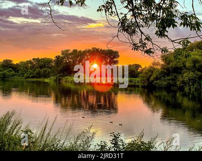 Schenectady, NY - USA - 6. Aug 2022 Landschaftsansicht auf den Sonnenuntergang auf dem Mohawk River, von der Gateway Landing des Schenectady Community College, p Stockfoto