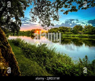 Schenectady, NY - USA - 6. Aug 2022 Landschaftsansicht auf den Sonnenuntergang auf dem Mohawk River, von der Gateway Landing des Schenectady Community College, p Stockfoto