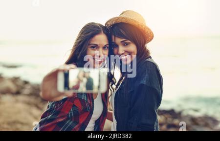 Zwei junge Freunde, die draußen zusammen ein Selfie machen. Stockfoto