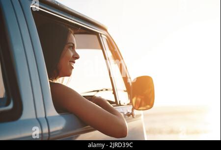 Der Sommer ist noch besser, wenn Sie unterwegs sind. Eine attraktive junge Frau genießt einen Roadtrip. Stockfoto
