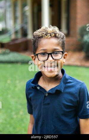 Nahaufnahme eines süßen afroamerikanischen Jungen mit Brille und einem großen Lächeln Stockfoto