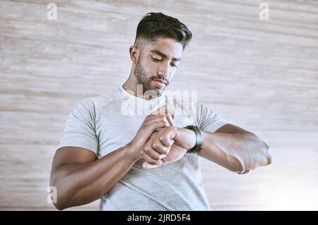 Mann mit digitaler Smartwatch für die Verfolgung von Gesundheit, Fitness und Leistungsfortschritt nach dem Training oder Training. Starker und gesunder junger Mann oder Athlet Stockfoto