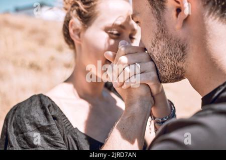 Engagement, Liebe und Romantik mit Paar Vorschlag und speichern Sie das Datum Ziel. Nahaufnahme eines Mannes, der die Hände der Frau festhält und küsst, während er sich glücklich fühlt Stockfoto