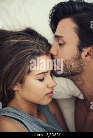 Es ist ein Zeichen der wahren Liebe. Aufnahme eines anhänglichen jungen Paares, das im Bett intime Aufnahmen gemacht hat. Stockfoto