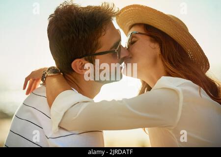 Der Sommer ist eine romantische Zeit. Ein junges Paar küsst sich an einem Sommertag im Freien. Stockfoto