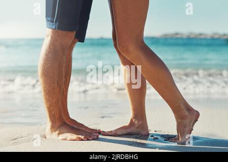 Sommer hier. Ein unverkennbares Paar, das am Strand am Rand des Wassers zusammensteht. Stockfoto