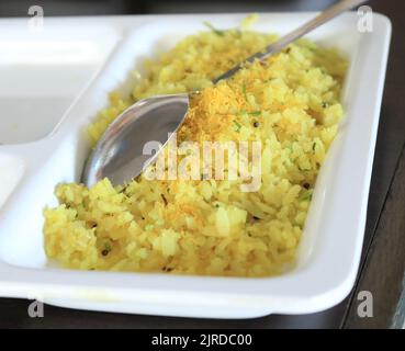 Eine Nahaufnahme eines Poha-Gerichts mit abgeflammtem Reis, das von maharashtrianischen Menschen zum Frühstück verwendet wurde. Stockfoto