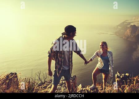 Sie haben einen doppelten Fall von Fernweh bekommen. Ein liebevolles junges Paar, das sich während einer gemeinsamen Wanderung verbindet. Stockfoto