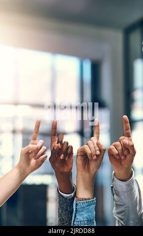 Setzen Sie Ihre Sehenswürdigkeiten hoch. Eine Gruppe von nicht erkennbaren Geschäftsleuten zeigt nach oben. Stockfoto