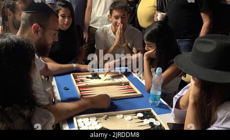 Israelis und Araber spielen ein Backgammon-Tischspiel während des Jerusalem Double Backgammon-Meisterschaftsturniers, das am 23. August 2022 im christlichen Viertel in der Altstadt in Jerusalem, Israel, stattfindet. Backgammon, auch Shesh-besh genannt, stammt aus tausenden von Jahren und wird sowohl von Arabern als auch von Juden gespielt. Stockfoto