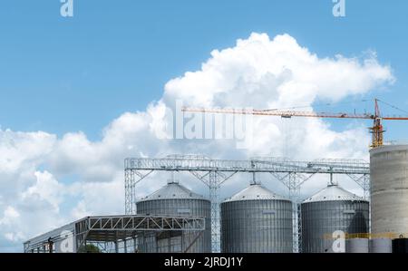 Baustelle der Futtermittelfabrik. Landwirtschaftliche Silo in der Futtermittelfabrik. Tank für Lagergetreide in der Futtermittelherstellung. Saatgutturm für Pendler Stockfoto