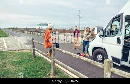 Weibliche Mechanikerin, die den Wohnmobil eines Paares auf einer Reise fixiert Stockfoto