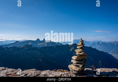 Landschaft mit Bergen, Himmel und Wolken. Rock Balancing, Stone Stacking Art. Land Art. Rochers de Naye, Montreux, Schweiz im Sommer. Ruhiges Scen Stockfoto