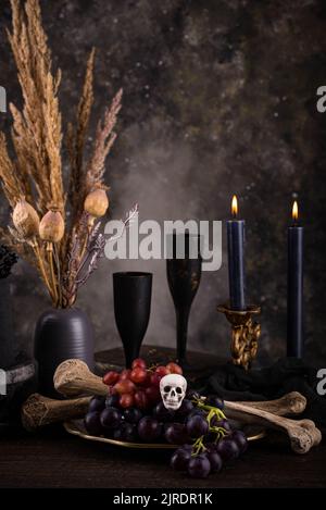 Halloween Stillleben mit Totenkopf, Knochen und Kuchen Stockfoto