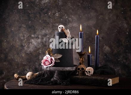 Halloween Stillleben mit Totenkopf, Knochen und Kuchen Stockfoto