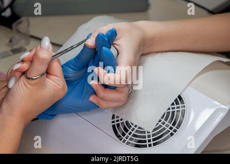Beauty-Therapeut tut Maniküre auf der Hand der jungen asiatischen Frau. Stockfoto