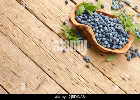 Frische Heidelbeeren in Holzschale auf Plankenhintergrund Stockfoto
