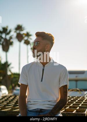 Ein junger, hübscher spanischer Mann mit stilvoller Frisur und Tattoos Stockfoto