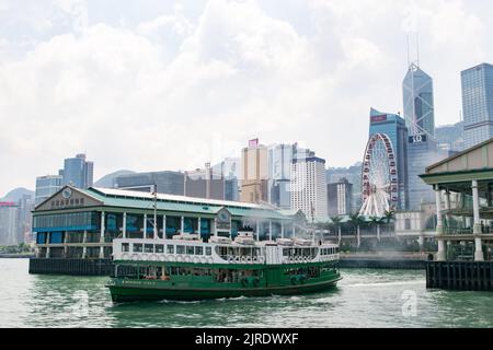 Star Ferry auf dem Weg zum Central Pier Hafen mit Hongkongs Wolkenkratzern im Hintergrund. Stockfoto