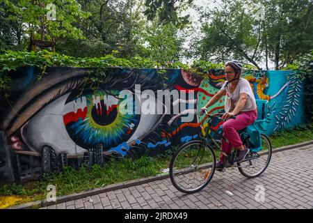 Krakau, Polen. 23. August 2022. Ein Radfahrer kommt an einem neu bemalten Wandgemälde vorbei, das die polnische Solidarität mit der Ukraine während der russischen Invasion zeigt. Krakau, Polen, am 23. August 2022. Das Wandgemälde wurde vom polnischen Straßenkünstler Mikolaj Rejs mit Hilfe ukrainischer Kinder und des kalifornischen Künstlers Benjamin Ssatez von der gemeinnützigen Organisation Goodness Tour gemalt. (Bild: © Beata Zawrzel/ZUMA Press Wire) Stockfoto