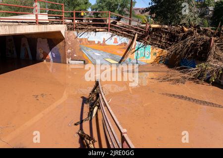 Die Leitplanke wurde in der Nacht zuvor in Moab, Utah, aus ihren Befestigungen gerissen und über den überfluteten Gehweg von der Sturzflutung des Mill Creek gebogen. Stockfoto