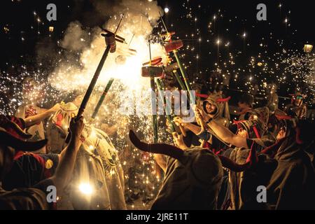 Sitges, Spanien. 24. August 2022. „Diables de Sitges - Colla Jove“ versammeln sich, um ihre auf dem Stock montierten Feuersündel während des traditionellen Morgens „Correfoc“ auf dem „Festa Major de Sitges“ zu erleuchten. Quelle: Matthias Oesterle/Alamy Live News Stockfoto