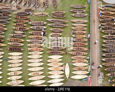 Manikganj, Dhaka, Bangladesch. 24. August 2022. Hunderte von handgefertigten Holzbooten stehen auf dem größten Bootsmarkt von Bangladesch in Manikgonj, Bangladesch, zum Verkauf. Wird von den Einheimischen während des Monsuns verwendet Wenn starke Niederschläge das Flussufer zum Platzen bringen, kostet jedes Schiff zwischen Â£30 und Â£80, abhängig von seiner Größe und der Qualität der verwendeten Materialien. Die Menschen strömten auf den Freiluftmarkt, um Boote zu kaufen, um sich auf die kommende Regenzeit vorzubereiten. Kredit: ZUMA Press, Inc./Alamy Live Nachrichten Stockfoto