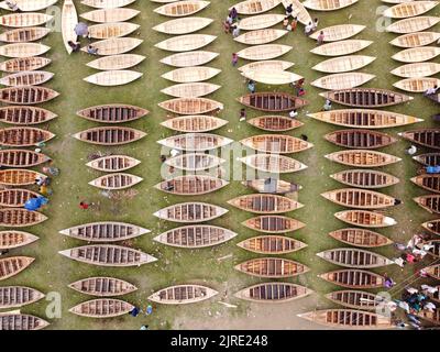 Manikganj, Dhaka, Bangladesch. 24. August 2022. Hunderte von handgefertigten Holzbooten stehen auf dem größten Bootsmarkt von Bangladesch in Manikgonj, Bangladesch, zum Verkauf. Wird von den Einheimischen während des Monsuns verwendet Wenn starke Niederschläge das Flussufer zum Platzen bringen, kostet jedes Schiff zwischen Â£30 und Â£80, abhängig von seiner Größe und der Qualität der verwendeten Materialien. Die Menschen strömten auf den Freiluftmarkt, um Boote zu kaufen, um sich auf die kommende Regenzeit vorzubereiten. Kredit: ZUMA Press, Inc./Alamy Live Nachrichten Stockfoto