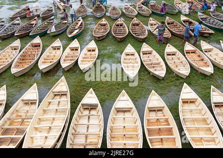 Manikganj, Dhaka, Bangladesch. 24. August 2022. Hunderte von handgefertigten Holzbooten stehen auf dem größten Bootsmarkt von Bangladesch in Manikgonj, Bangladesch, zum Verkauf. Wird von den Einheimischen während des Monsuns verwendet Wenn starke Niederschläge das Flussufer zum Platzen bringen, kostet jedes Schiff zwischen Â£30 und Â£80, abhängig von seiner Größe und der Qualität der verwendeten Materialien. Die Menschen strömten auf den Freiluftmarkt, um Boote zu kaufen, um sich auf die kommende Regenzeit vorzubereiten. Kredit: ZUMA Press, Inc./Alamy Live Nachrichten Stockfoto