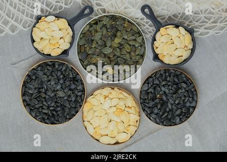 Kürbis- und Sonnenblumenkerne in einer Schüssel. Getrocknete Getreidesamen und Früchte. Lebensmittelzutaten. Stockfoto