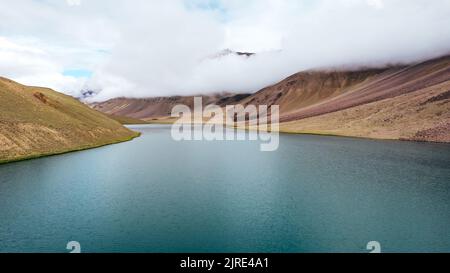 Breite Luftaufnahme des Chandra Taal Sees mit gletscherblauem Wasser, umgeben von Himalaya-Bergen in Nordindien Stockfoto