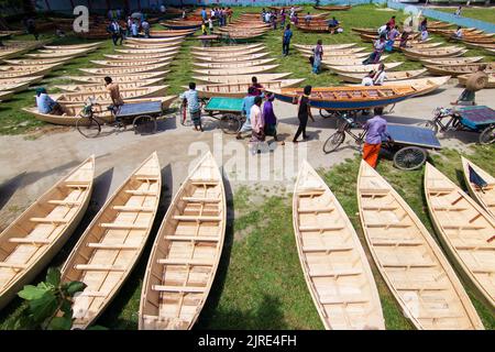 Manikganj, Dhaka, Bangladesch. 24. August 2022. Hunderte von handgefertigten Holzbooten stehen auf dem größten Bootsmarkt von Bangladesch in Manikgonj, Bangladesch, zum Verkauf. Wird von den Einheimischen während des Monsuns verwendet Wenn starke Niederschläge das Flussufer zum Platzen bringen, kostet jedes Schiff zwischen Â£30 und Â£80, abhängig von seiner Größe und der Qualität der verwendeten Materialien. Die Menschen strömten auf den Freiluftmarkt, um Boote zu kaufen, um sich auf die kommende Regenzeit vorzubereiten. Kredit: ZUMA Press, Inc./Alamy Live Nachrichten Stockfoto