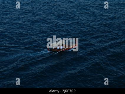 Eine Luftaufnahme eines Bootes mit Menschen, die im Meer in Valletta segeln Stockfoto