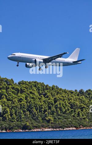 Eine vertikale Aufnahme einer Landung A320 auf dem Flughafen Skiathos in Griechenland Stockfoto