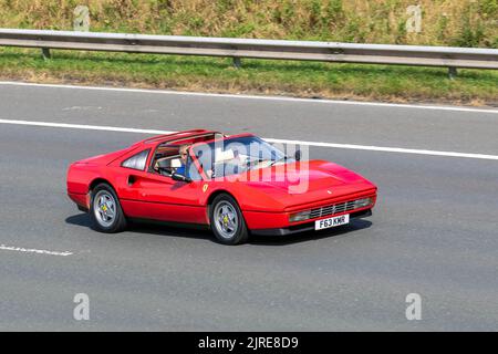 1989, 80s, achtziger Jahre Rot, Rosso Corsa FERRARI 328, Mittelmotor V8, zweisitzige Keilprofil-Sportwagen 3185cc Benzin Italienisch, Targa Roadster; sich bewegend, gefahren, in Bewegung, Anfahrt auf der Autobahn M6, Großbritannien Stockfoto