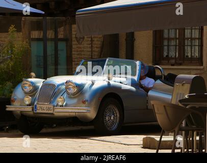 Das klassische silberne Jaguar XK140-Auto parkte auf der Plaza de Marques neben dem Crooked House Restaurant Saldana Saldaña Palencia Castile and Leon Spain Stockfoto