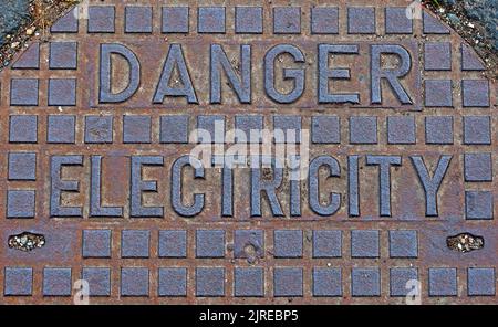 Gefahr - Elektrizität, rostendes Gusseisennetz, England, Großbritannien Stockfoto