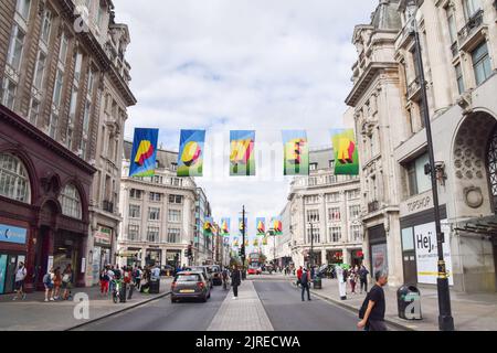 London, Großbritannien. 24.. August 2022. Entlang der Oxford Street wurde eine Kunstinstallation mit Fahnen mit der Aufschrift „Time for Clean Power“ aus recyceltem Ozeanplastik installiert, um den Wechsel zu erneuerbaren Energien zu fördern. Die Installation wurde vom britischen Künstler Morag Myerscough entworfen, der Teil einer von #TOGETHERBAND finanzierten Kampagne ist. Kredit: Vuk Valcic/Alamy Live Nachrichten Stockfoto