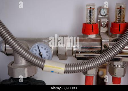 Heizsystem Ventilblock für Heizboden und Wasserversorgung in einem Landhaus. Rohrkollektor in einem Gebäude im Bau. Stockfoto