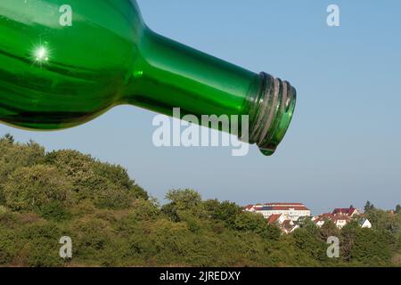 Eine leere Wasserflasche über der durstigen Stadt. Wenn Wasser aufgrund des Klimawandels knapp wird. Stockfoto