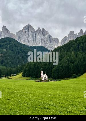 Kirche St. Johann, St. Johann, Val di Funes in den Dolomiten mit dem Seceda-Gebirge Barockkapelle mit einem kupferkuppelierten Glockenturm und Fresken Stockfoto