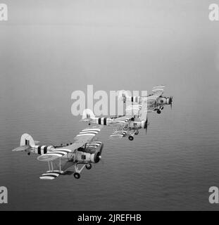 Rakete - bewaffnete Fairey Swordfish auf einem übungsflug von Rnas, St Merryn in Cornwall, 1. August 1944. Drei Rakete Projektil Fairey Swordfish bei einem von St Merryn Royal Naval Air Station Dieses operationelle Geschwader wurde von Lieutenant Commander P Schnee RN geboten. Beachten Sie die Invasion Streifen für die Landung in der Normandie auf dem Flügel und Rumpf des Flugzeugs befördert. Stockfoto