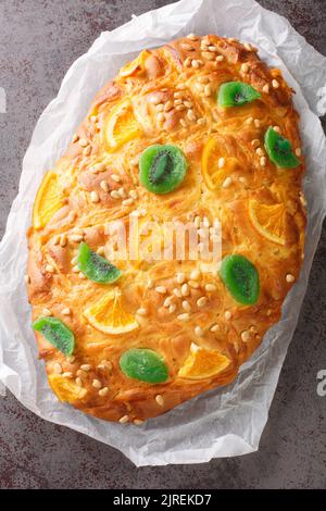 Coca de Sant Joan ist eines der beliebtesten Coques, Hefebrote, in Katalonien mit Creme und dekoriert mit Pinienkernen, kandierte Früchte Nahaufnahme auf der Stockfoto