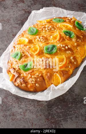 St Johns Kuchen Coca de sant joan mit Pinienkernen, kandierte Früchte Nahaufnahme auf dem Papier auf dem Tisch. Vertikal Stockfoto