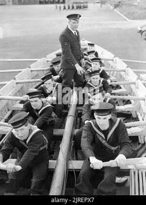 Naval Rekruten lernen ein Boot an HMS RALEIGH, die Naval training Basis in Yarmouth in Cornwall, 1941 an die Reihe. An HMS RALEIGH, die Naval training Basis in Yarmouth, Cornwall, neue Rekruten für die Marine lernen zu ziehen (Row) ein Boot auf dem Trockenen, zur Vorbereitung der Anweisung in der Nähe auf dem Wasser. Dieses Foto ist aus einer Serie von Bildern an die Fortschritte der einen Mann (John Smith) Eintritt in die Royal Navy und durch Training genommen. Stockfoto